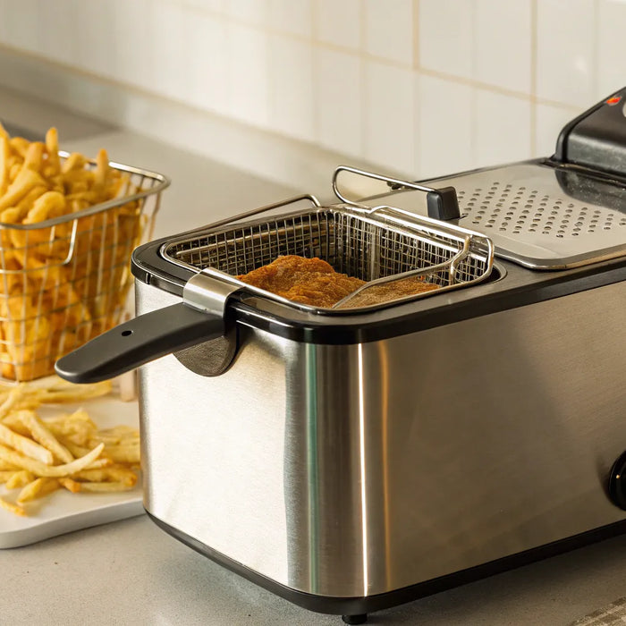 Deep fryer cooking crispy chicken and fries.