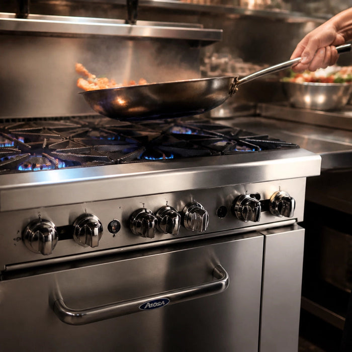Commercial Atosa AGR gas range on a restaurant cookline with open burners lit and stockpots in service