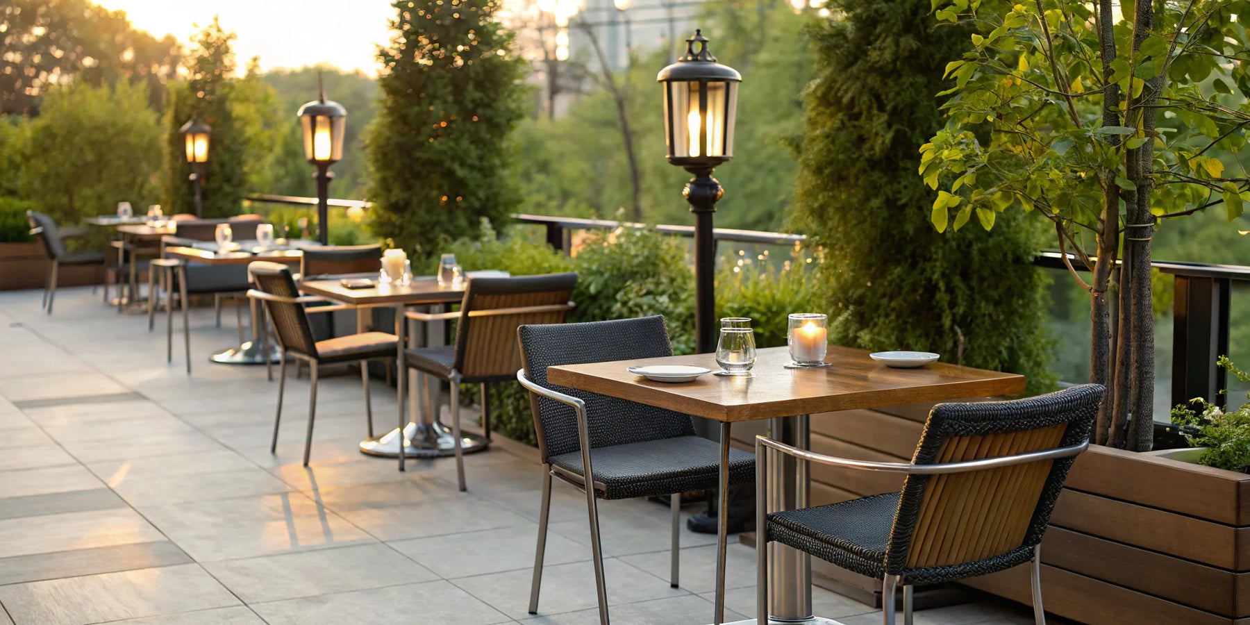 Outdoor restaurant tables set for evening dining on a commercial patio.