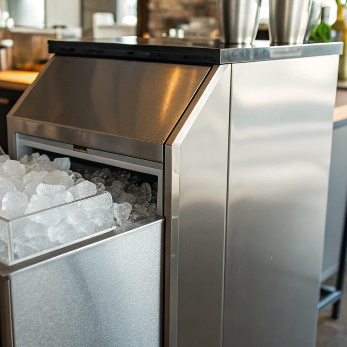 A stainless steel Atosa ice machine full of fresh ice in a commercial kitchen.
