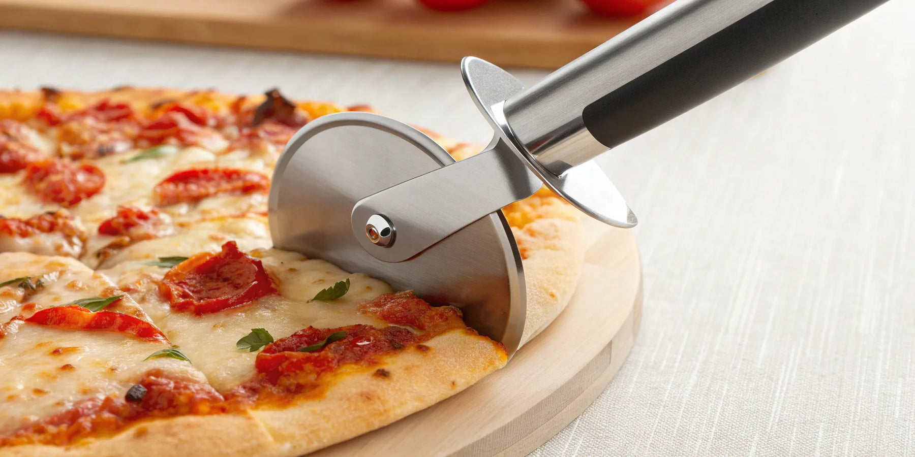 Cuter pizza wheel slicing hot pizza.