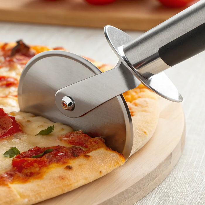 Cuter pizza wheel slicing hot pizza.
