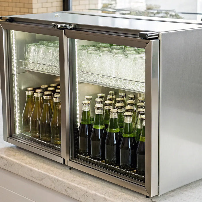 Chilled bottles and glasses in a stainless steel cooler.