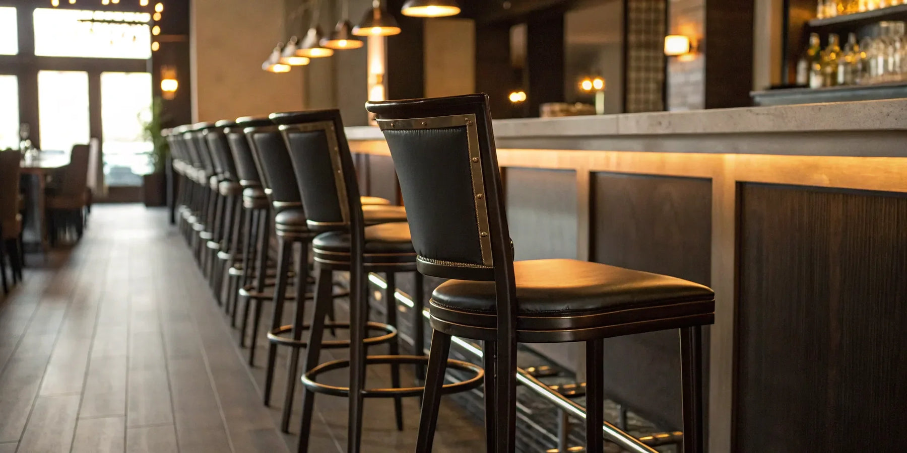 Upholstered commercial bar stools with metal frames at a modern bar.