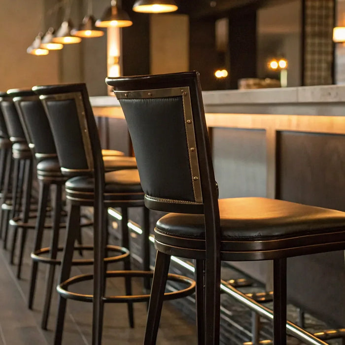 Upholstered commercial bar stools with metal frames at a modern bar.