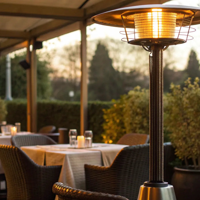 A commercial outdoor heater warming a restaurant patio with dining tables.