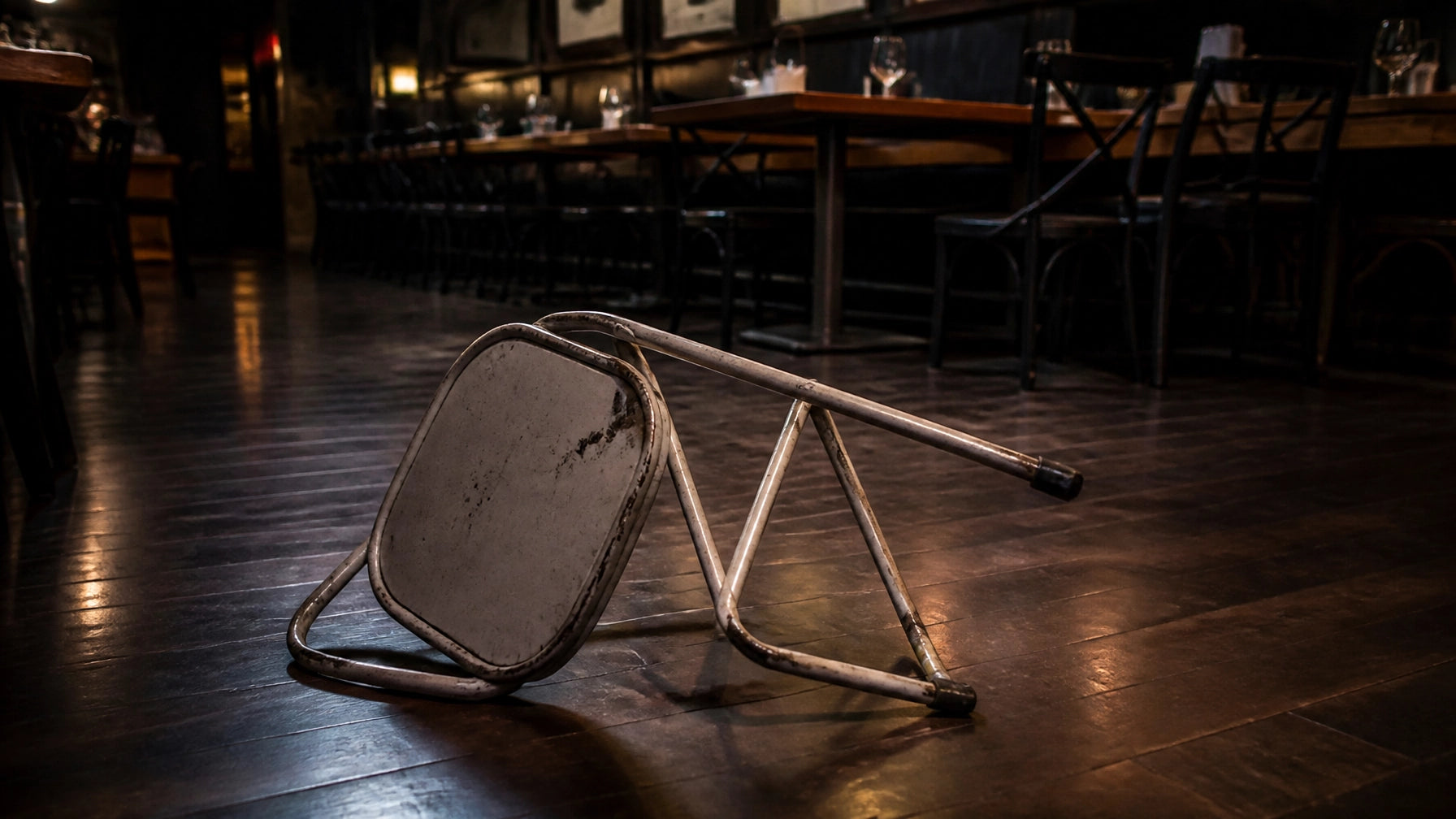 Damaged folding chair on a restaurant floor - illustrating the liability risk of residential-grade seating in commercial venues