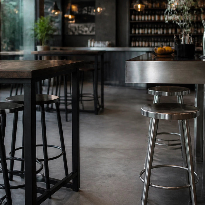 Modern restaurant setting featuring wood and stainless steel bar tables with bar-height stools in a warm, authentic atmosphere.