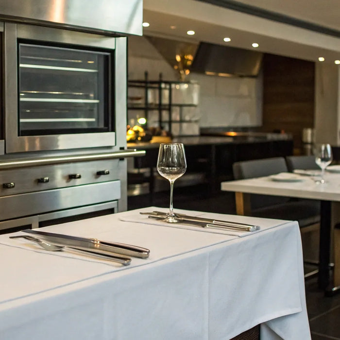 Restaurant kitchen with stainless steel appliances and dining area.