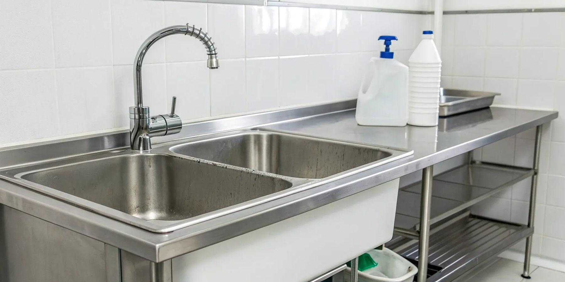 A stainless steel commercial janitorial sink with a deep basin and faucet.
