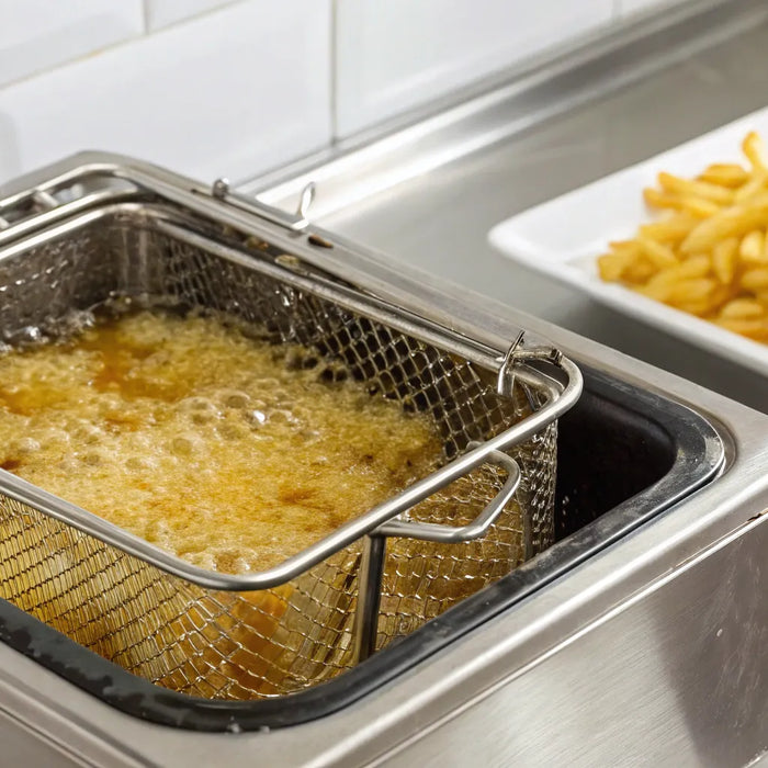 A commercial tabletop deep fryer with a basket of golden French fries.
