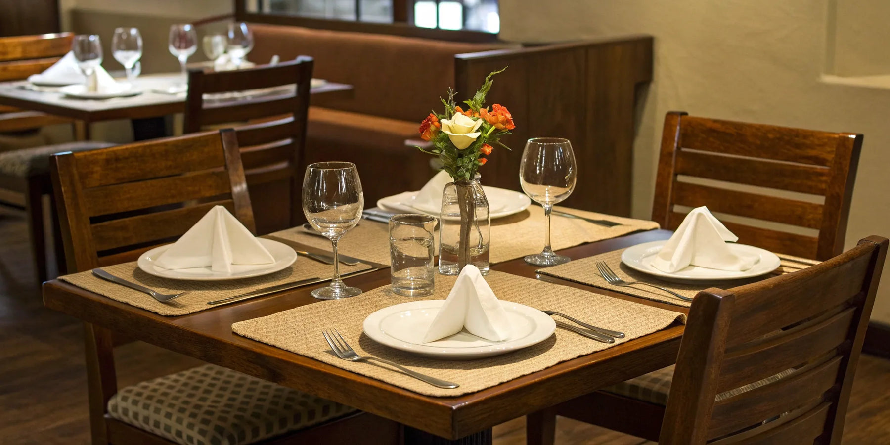 Stylish restaurant dining set with wooden chairs and elegant tableware.