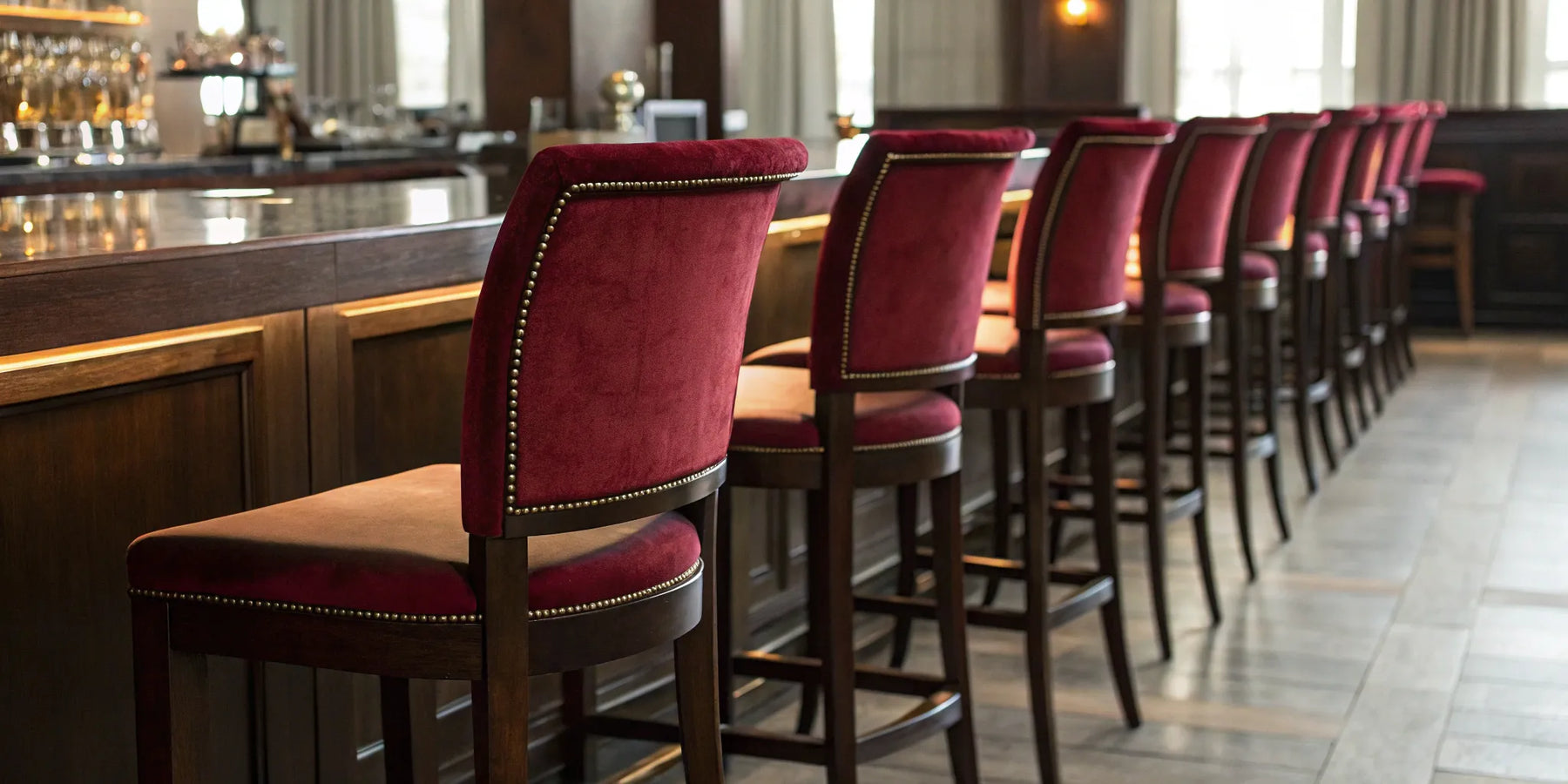 Commercial bar chairs with red upholstery at a bar.