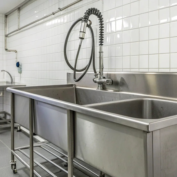 Stainless steel commercial mop sink with dual basins and a high backsplash.