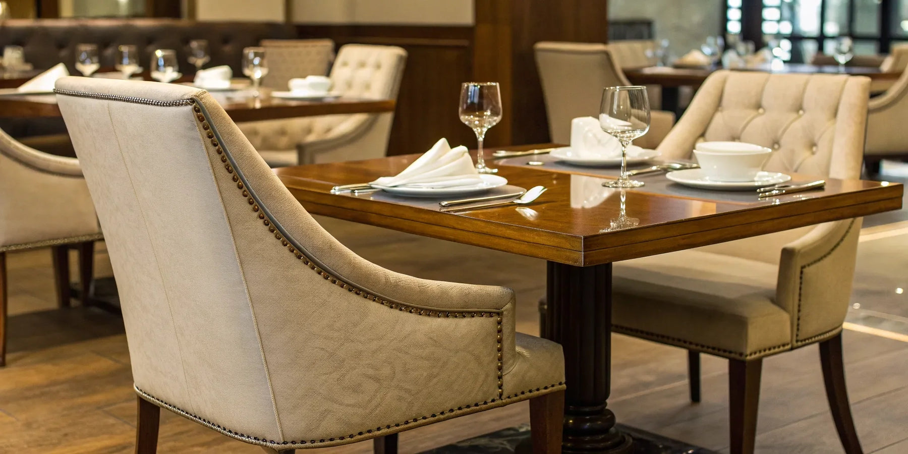 Restaurant table with upholstered chairs and glassware.