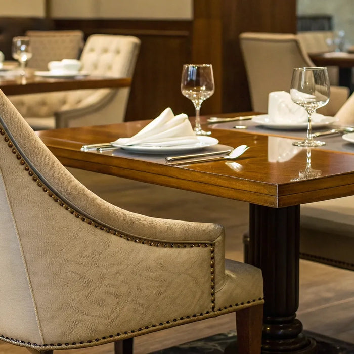 Restaurant table with upholstered chairs and glassware.