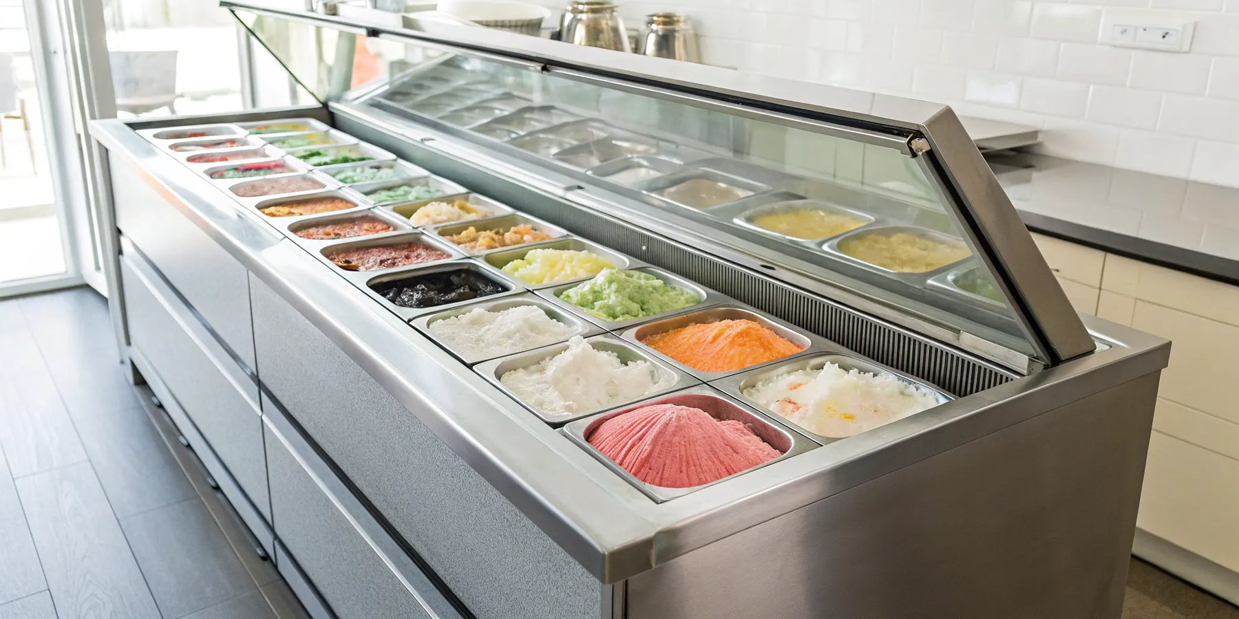 Commercial ice cream fridge displaying colorful flavors in a modern shop.