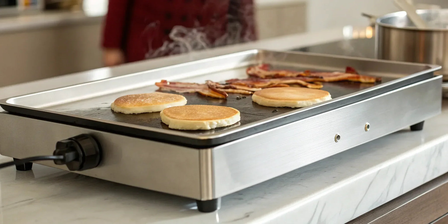 Extra large electric griddle cooking a family breakfast of pancakes and bacon.
