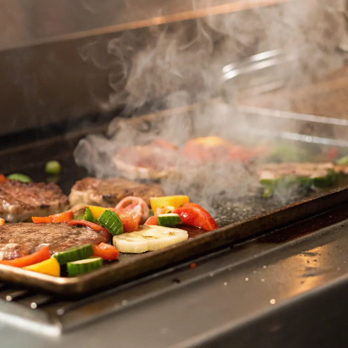 Sizzling meats and fresh vegetables on a restaurant griddle.