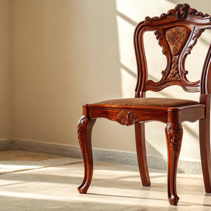 Classic cherry wood chair with ornate carved details and an upholstered seat.
